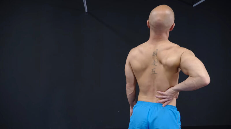 Man holding his hand on his back, practicing safe weiughtlifting techniques for his back